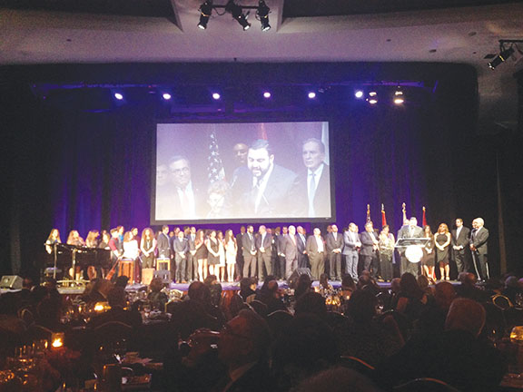 Current and former AYF members, including Nikki Smith, who was sworn in by Karekin Njdeh, flock to the stage as AYF is awarded the Vahan Cardashian Award