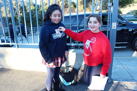 Students placing the "Hayakhos Vakrer: Hye Enk Menk” stickers.