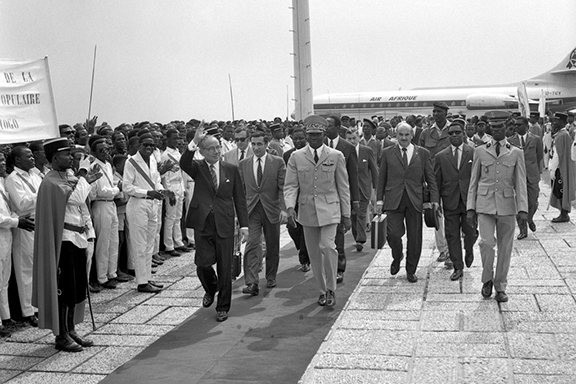 Secretary-General U Thant greets the gathering that welcomed him upon his arrival in Togo in January 1970. At right is the President of Togo, Etienne Eyadama. At centre is Jean Gazarian, Senior Officer, Executive Office of the Secretary-General. (Source: UN Photo)