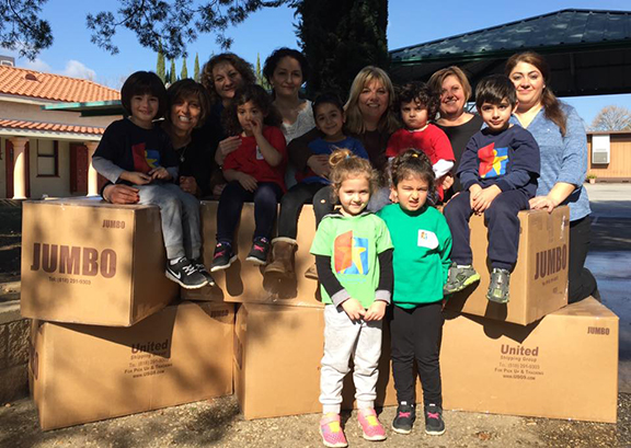 Students and teachers of Holy Martyrs A.R.S. Ashkhen Pilavjian Preschool with boxes of clothing. 