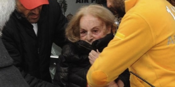 79-year-old Seta Demirci is being escorted to an ambulance after being found bound and gagged in her apartment in Istanbul