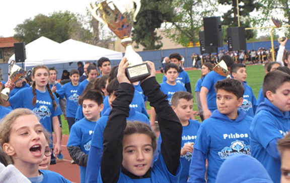 Pilibos students proudly holding up their trophy.