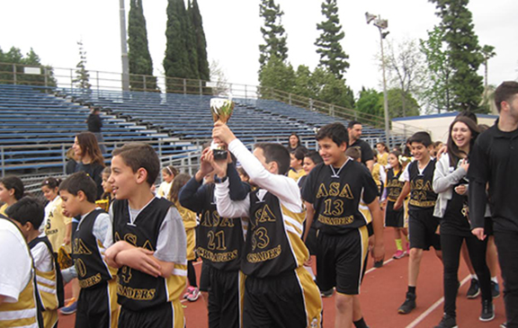 Students of Armenian Sister's Academy raising their trophy up high.