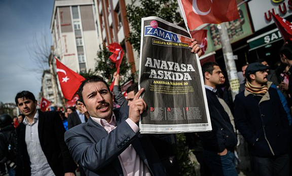 A protester holds a copy of Turkish newspaper Zaman during a demonstration in Istanbul on March 6. (Source: Ozan Kose/AFP/Getty Images)